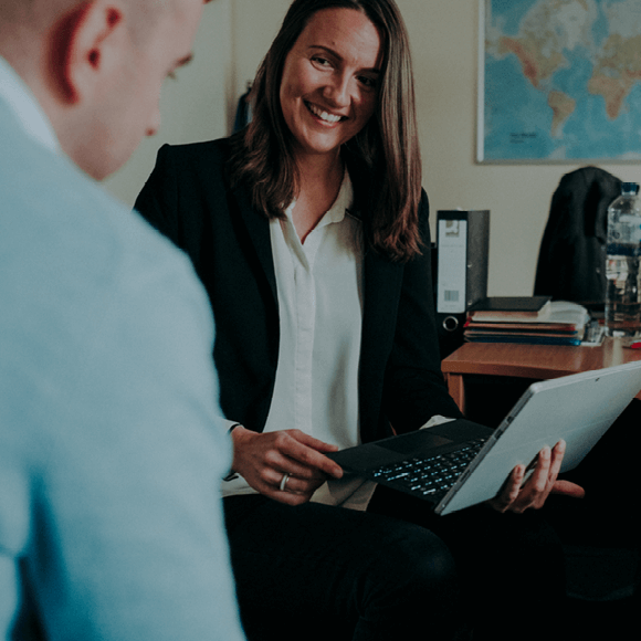 Two Tensar employees having a conversation with one holding a laptop