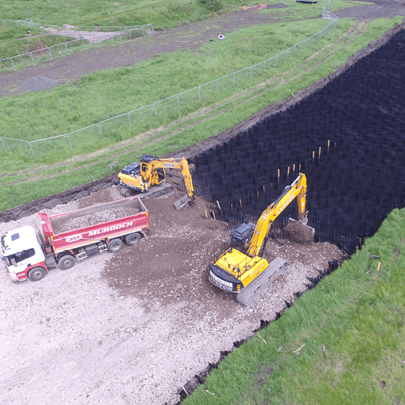 An ariel shot of three construction vehicles installing the TensarTech Stratum Cellular Foundation Mattress System