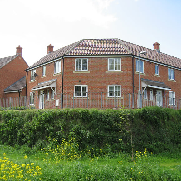 A residential housing estate with a green space in front of it