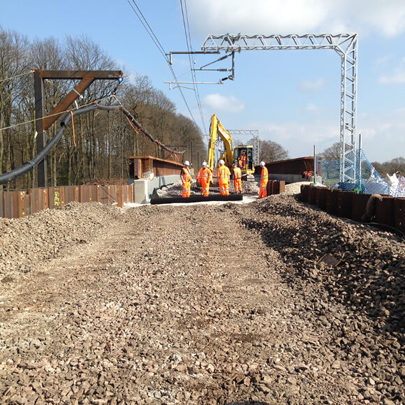 A group of construction workers using Tensar TriAx geogrid to mechanically-stabilise a track ballast in Cheshire, UK